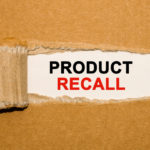 Brown cardboard with a rip in the center that reveals a white spot with the words "Product Recall" written in black and red lettering