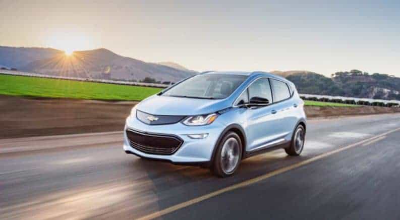 A Blue Chevy Bolt drives off into the sunset