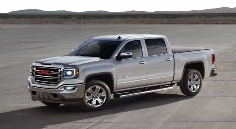 Silver 2016 GMC Sierra on runway with mountains in distance