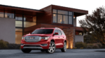 Red 2019 GMC Acadia Denali in front of wood and brick mansion