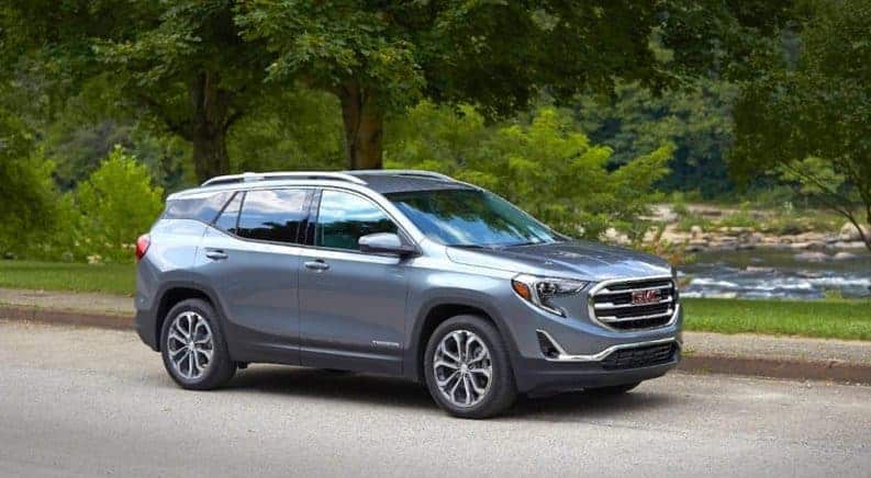 Gray 2019 GMC Terrain on road by woodland river