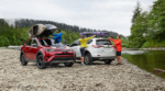 Red and white 2019 Toyota Rav4s with canoes next to river