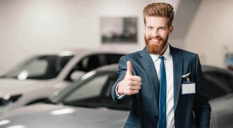 Beareded car salesman giving thumbs up