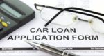 Buy here pay here with loan application, glasses, pen and calculator
