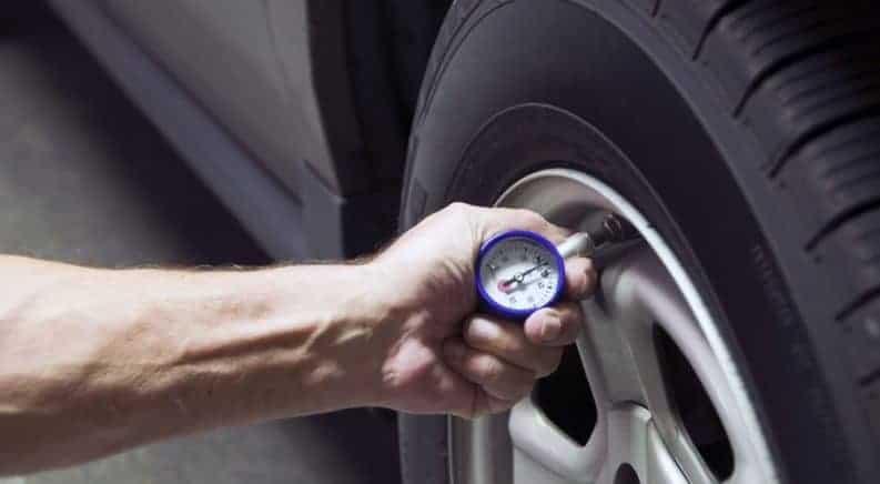 A man check tire pressure with an analog guage
