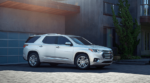 A white 2019 Chevy Traverse in front of a modern home