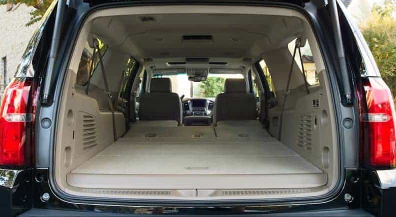 Rear cargo space of black 2019 Chevy Suburban with tan interior