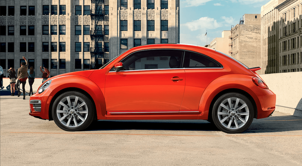 Orange 2019 Volkswagen on top of parking structure while people listen to concert in back