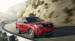 A red 2019 Ford Explorer drives a narrow mountain highway