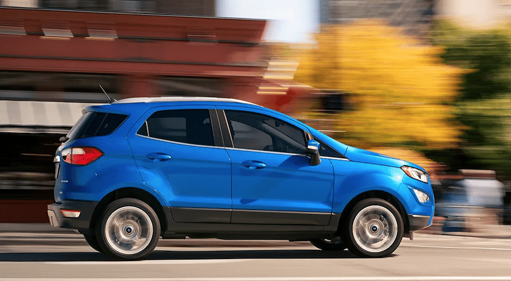 A blue Ford Ecosport drives a small town city road after leaving the local Ford Dealer