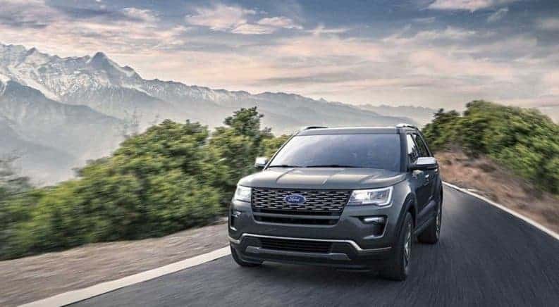 A dark gray 2019 Ford Explorer drives a narrow road high in the mountains