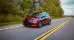 A red 2019 Chevy Bolt EV races along a mountain road