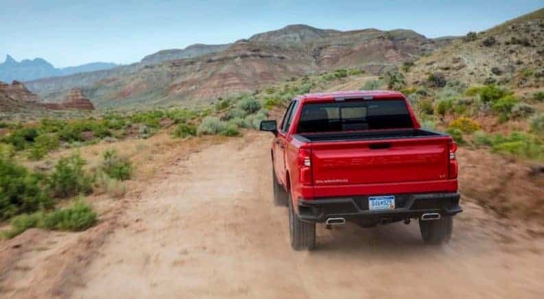 A red 2019 Chevy Silverado driving off in a desert