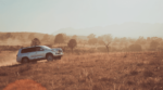 A silver 2019 Toyota Land Cruiser driving in a field