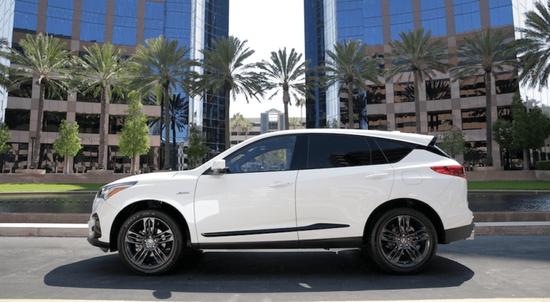 A white 2019 Acura RDX in front of a hotel
