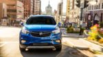A blue 2019 Buick Encore drives through a city