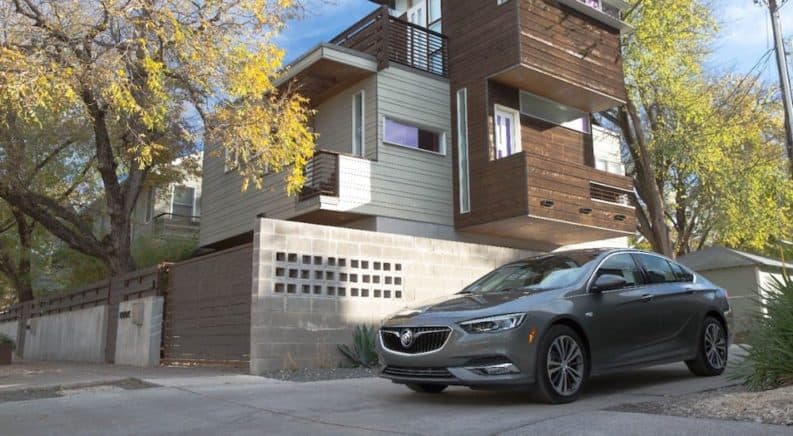 A gray 2019 Buick Regal Sportback in front of a modern home