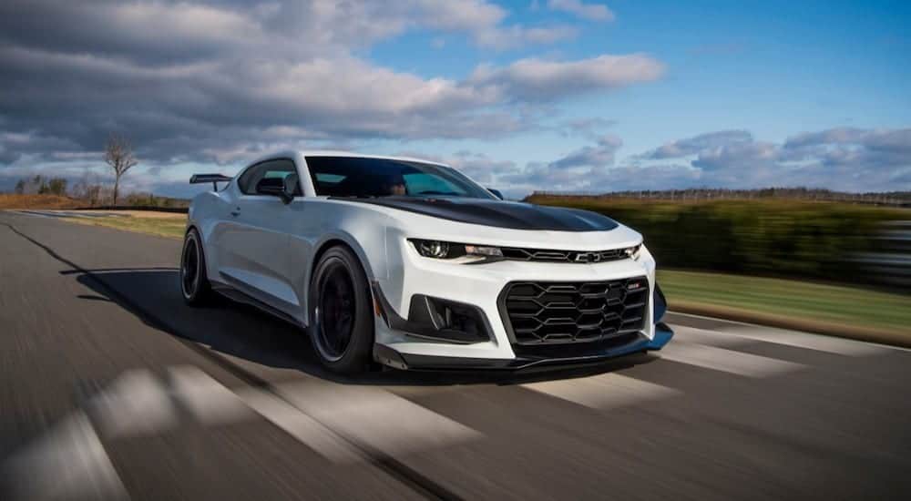 A white 2019 Chevy Camaro ZL1 races away with a win for 2019 Chevy Camaro vs 2019 Dodge Challenger