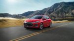 A red 2019 Chevy Cruze hatchback driving through a mountain pass