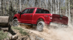 A red 2019 Ford F150 driving through the forest