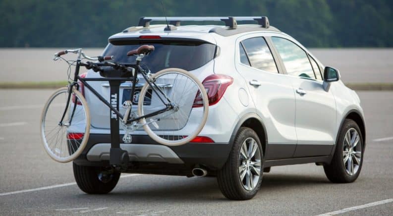 A white 2019 Buick Encore has a bike on the back.
