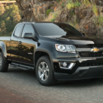 A black 2019 Chevy Colorado is driving on a winding mountain road.