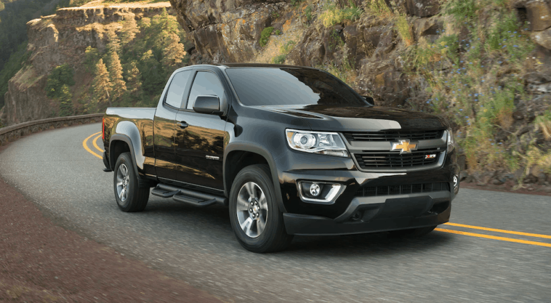 A black 2019 Chevy Colorado is driving on a winding mountain road.