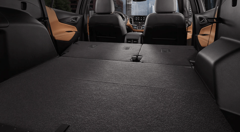 The black and tan cargo space of the 2019 Chevy Equinox is shown with the seats folded down. The better cargo space wins in the 2019 Chevy Equinox vs. 2019 Jeep Cherokee comparison. 