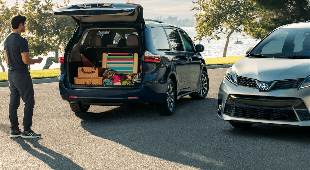 A man is unloading beach gear from his dark blue 2019 Toyota Sienna. Find the minivan at a Toyota dealership.