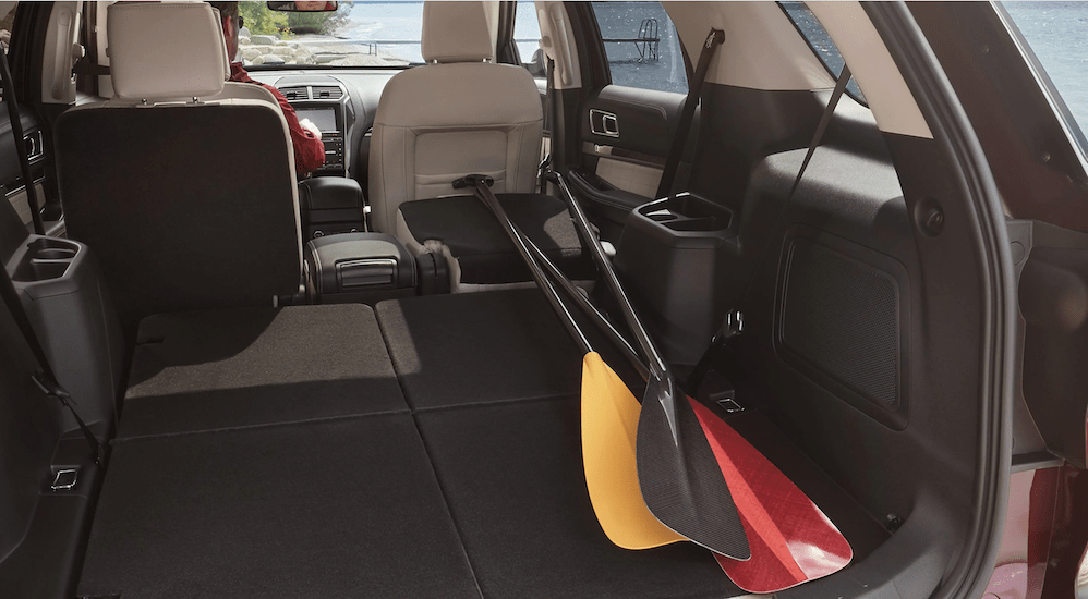 The seats of the 2020 Ford Explorer are folded down to show available cargo room with space for canoe paddles.