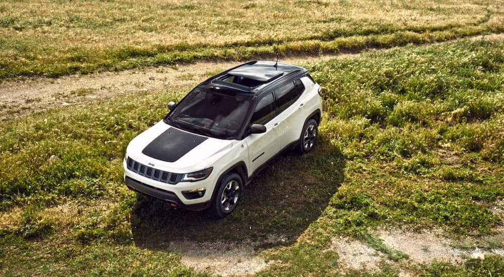 A white and black 2018 Jeep Compass is shown from above in a field.