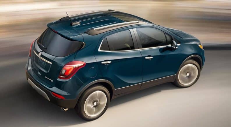 A blue 2019 Buick Encore is driving with a blurred background.