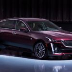 A burgundy 2020 Cadillac CT5 Premium Luxury is lit in a empty showroom.