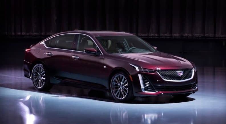 A burgundy 2020 Cadillac CT5 Premium Luxury is lit in a empty showroom.