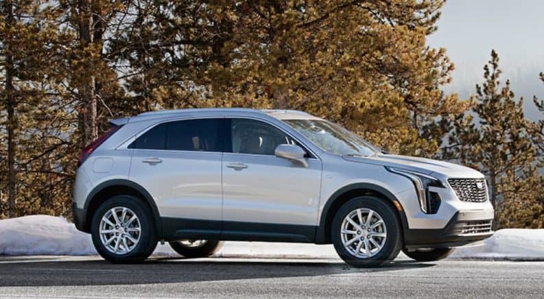 A silver 2019 Cadillac XT4 is parked in a snowy area and is a popular Cadillac for sale.