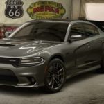 A grey 2019 Dodge Charger is parked in a garage with a Challenger leaving behind it. They can be found at any of the Dodge dealers in your area.