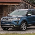 A blue 2019 Ford Explorer is parked in front of a barn.
