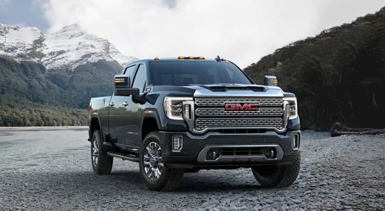 A grey 2020 GMC Sierra 2500HD Denali is parked with snowy mountains in the distance.