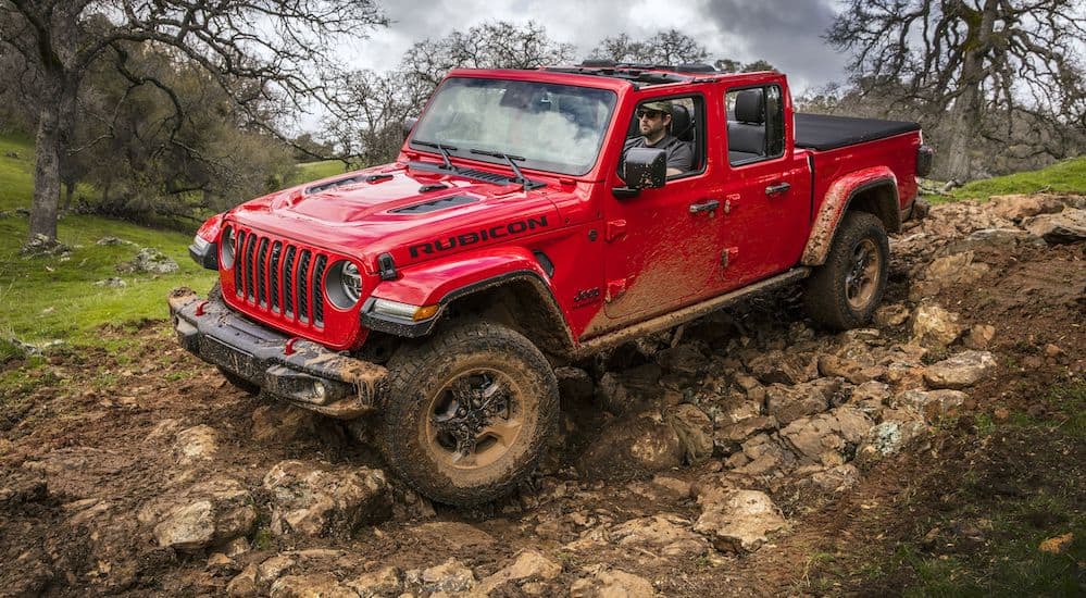 The performance of Jeep Gladiator wins when a 2020 Jeep Gladiator v 2019 Chevy Colorado are going back to back. A Jeep Gladiator is shown driving on rocks in the woods. 
