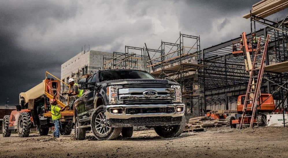A black 2019 Ford Super Duty in a construction area with a stormy sky in the background. 