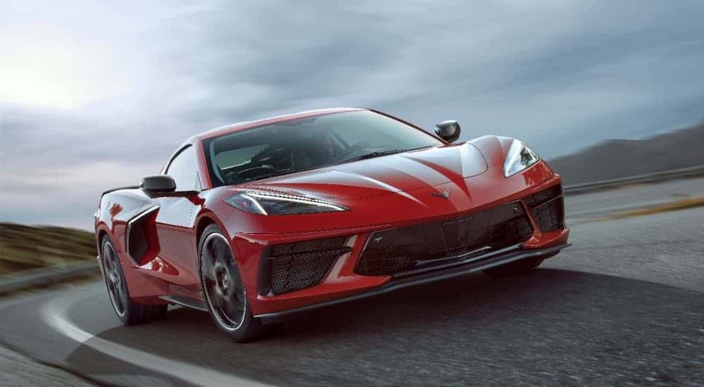 A red 2020 Chevy Corvette is shown driving around a corner.
