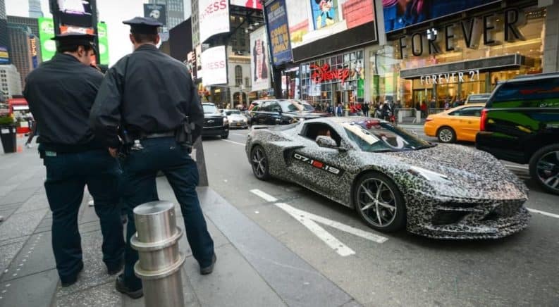 A camouflaged 2020 Chevy Corvette is next to police officers in NYC's Time Square.