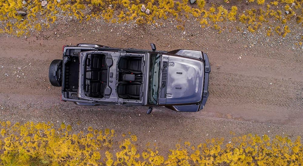 A dark grey 2019 Jeep Wrangler is shown from above on a dirt road.