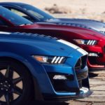 A red, a blue, and a silver 2020 Ford Mustang Shelby GT500 are parked on a racetrack.