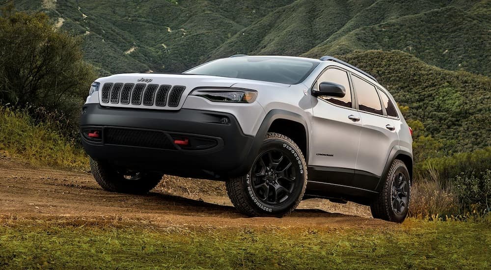 A silver 2019 Jeep Cherokee with black trim is parked on a high trail near Denver, CO.