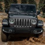 A black 2019 Jeep Wrangler is on a muddy trail after leaving a Jeep dealership in Denver.