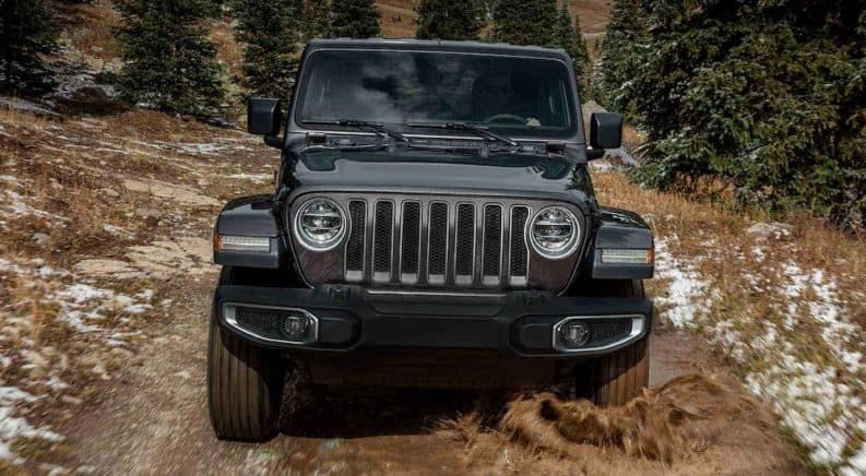 A black 2019 Jeep Wrangler is on a muddy trail after leaving a Jeep dealership in Denver.