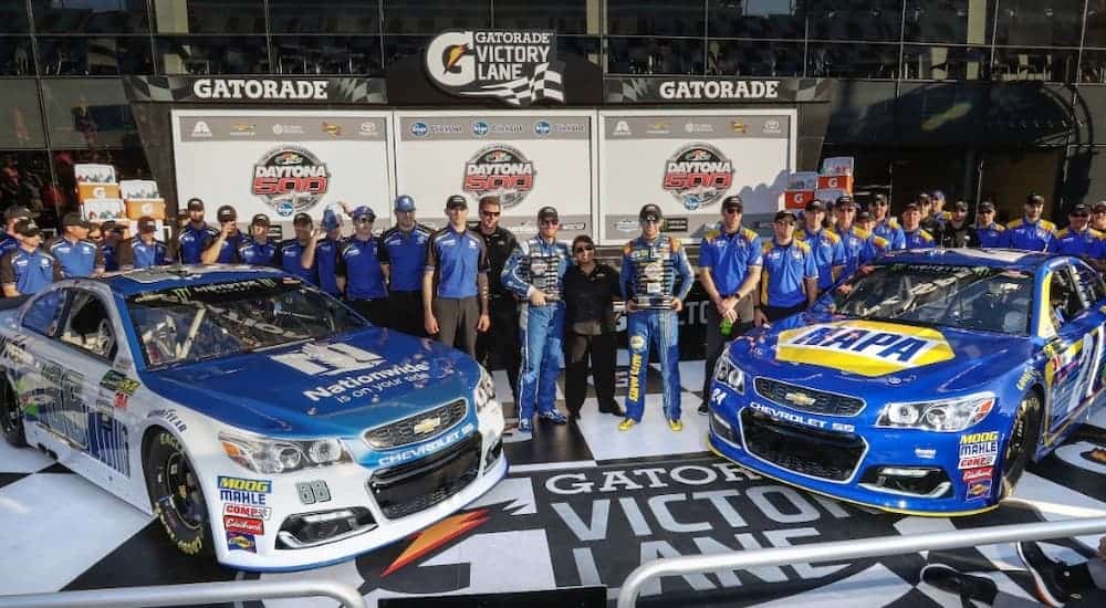 The Hendrick Racing team is shown with two of the cars.