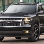 A black 2020 Chevy Suburban is parked in front of glass windows.