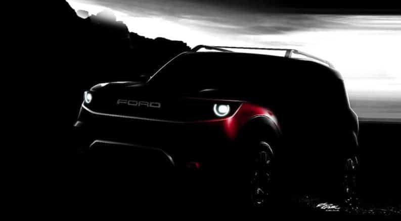 A silhouette of a red 2020 Ford Bronco is shown in dim light against a black and white sky